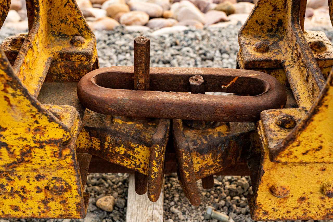 Close-up of a rusty metal coupling on yellow industrial machinery in Newton, UT.